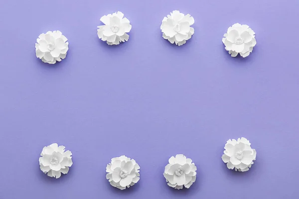 Frame made of beautiful origami flowers on violet background