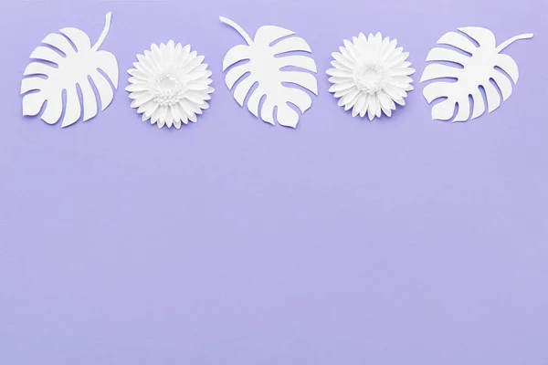 Origami flowers and leaves on violet background