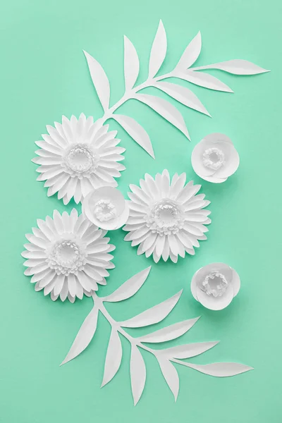 Beautiful composition with origami flowers and leaves on color background