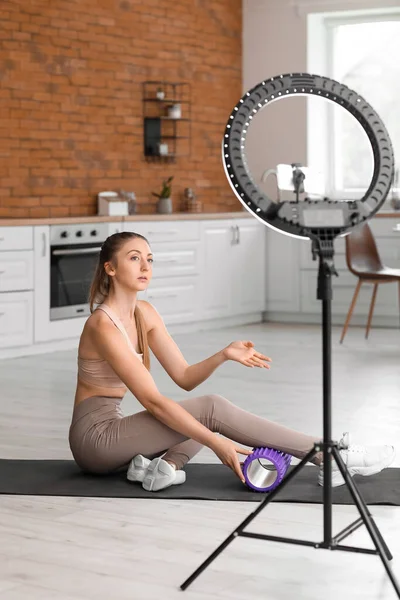 Young Woman Foam Roller Recording Video Kitchen — стоковое фото