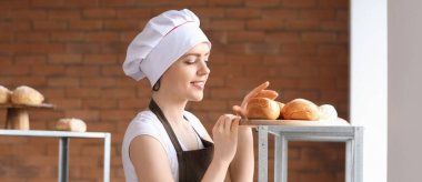 Mutfakta taze çörekleri olan kadın fırıncı.