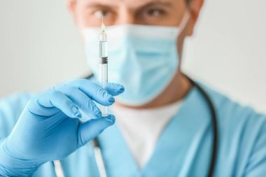 Klinikte şırıngalı erkek doktor, yakın plan.