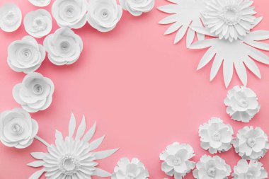 Kağıt çiçeklerden yapılmış çerçeve ve pembe arkaplanda yapraklar