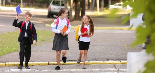 Cute little students crossing road