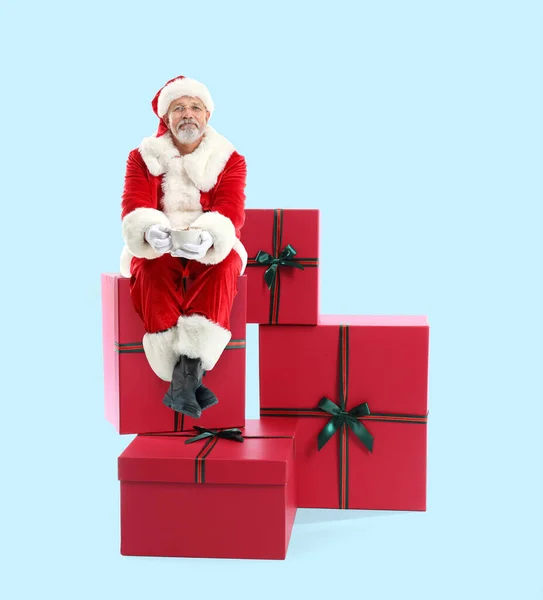 Portret Świętego Mikołaja Gorącą Czekoladą Siedzącą Dużych Prezentach Niebieskim Tle — Zdjęcie stockowe