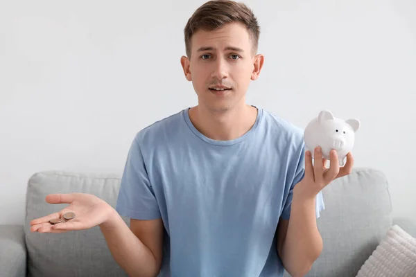 Upset Young Man Holding Piggy Bank Coins Home — Stock Photo, Image