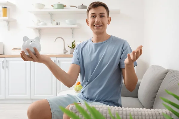 Happy Young Man Holding Piggy Bank Kitchen — Stock Photo, Image
