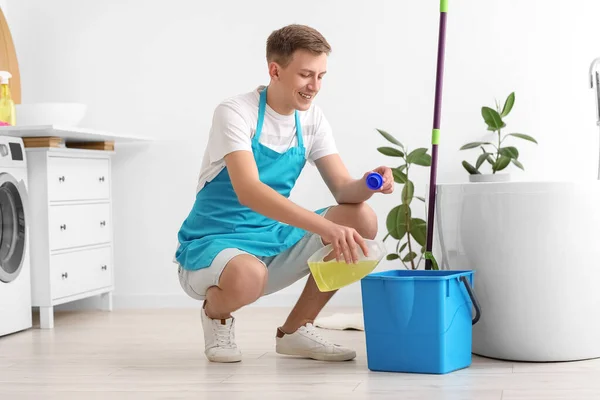 Young Man Pouring Detergent Bucket Bathroom — Stockfoto