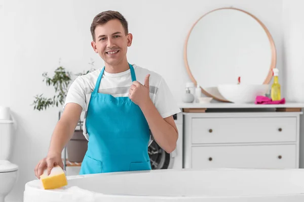Young Man Cleaning Bathtub Sponge Showing Thumb Room — Stockfoto