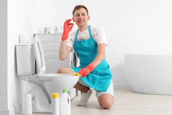 Young Man Cleaning Toilet Bowl Showing Bathroom — Foto de Stock