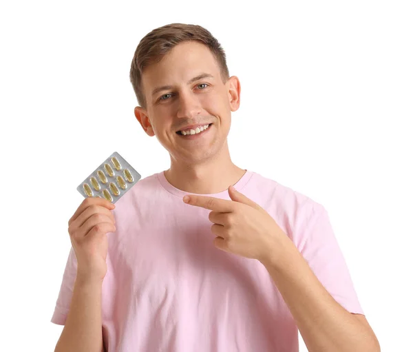 Young Man Pointing Blister Pills White Background — Stockfoto