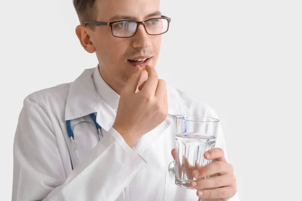 Młody Lekarz Szklanką Wody Biorąc Pigułkę Białym Tle — Zdjęcie stockowe