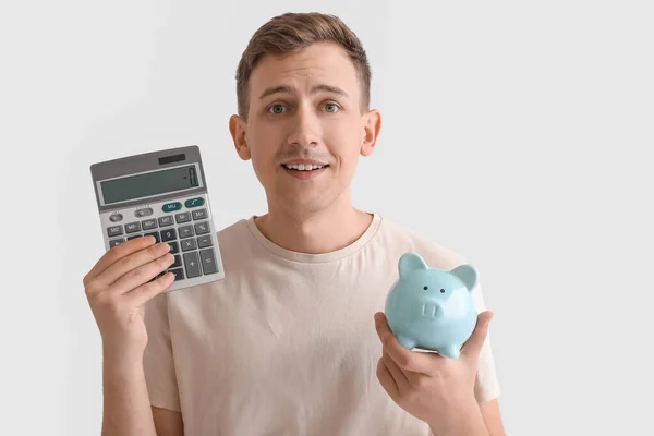 Young Man Blue Piggy Bank Calculator White Background — Stockfoto