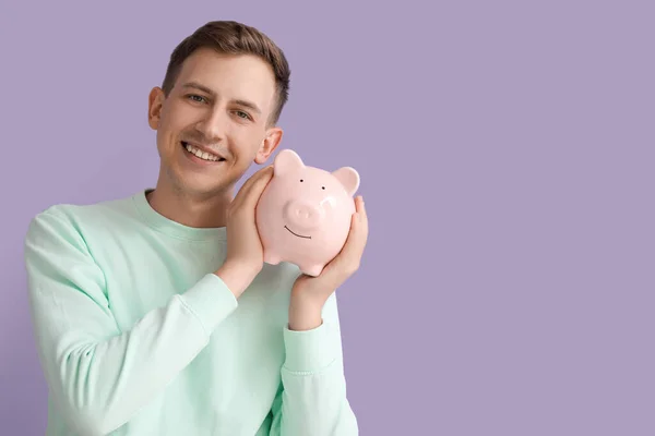 Young Man Pink Piggy Bank Violet Background — 图库照片