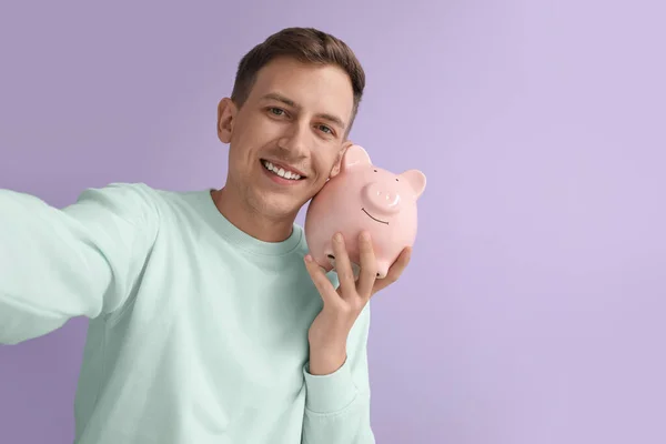 Young Man Pink Piggy Bank Violet Background — Stockfoto