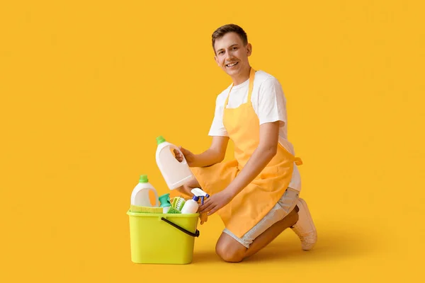 Young Man Bucket Cleaning Supplies Yellow Background — Fotografia de Stock
