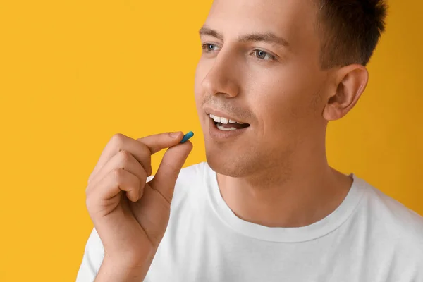 Young Man Taking Vitamin Yellow Background Closeup — Fotografia de Stock