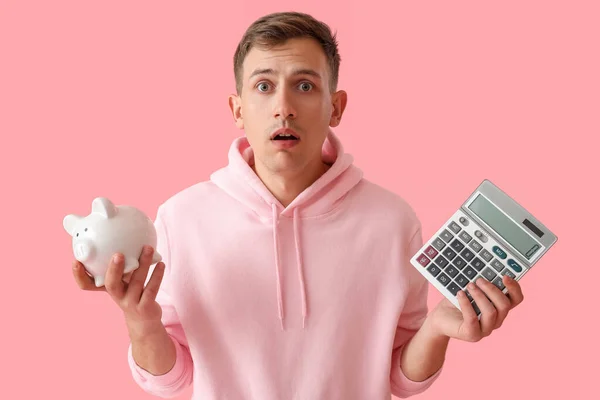 Shocked Young Man Piggy Bank Calculator Pink Background — Stock Photo, Image