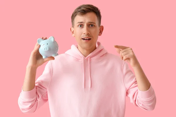 Young Man Pointing Blue Piggy Bank Pink Background — Stock Photo, Image