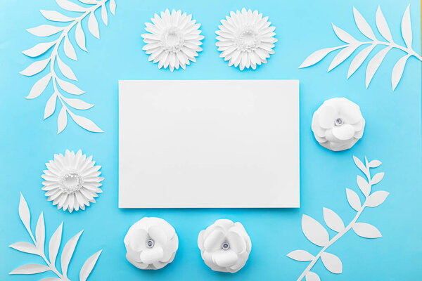Paper sheet with flowers and leaves on blue background