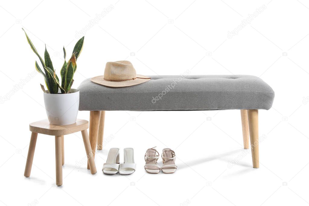 Soft bench with hat, shoes, stool and houseplant on white background