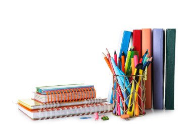 Cup with school stationery and books on white background