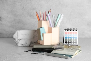 Okul kırtasiyesi olan kupalar ve grunge arkaplan üzerinde kalem kutusu