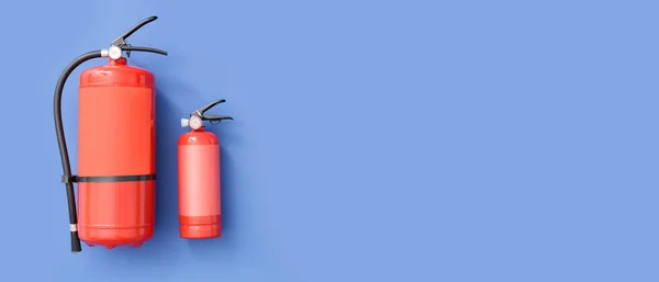 Fire extinguishers on blue background with space for text