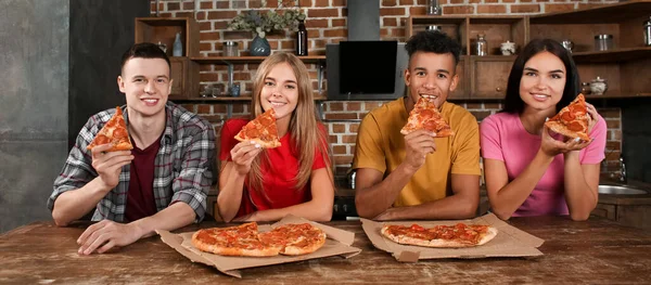 Young People Eating Delicious Pizza Kitchen — Zdjęcie stockowe