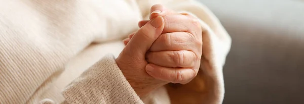 Hands of elderly woman at home, closeup