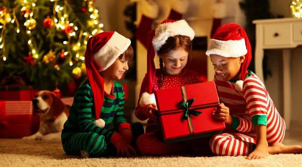 Cute Little Children Santa Hats Opening Christmas Gift Home — Zdjęcie stockowe