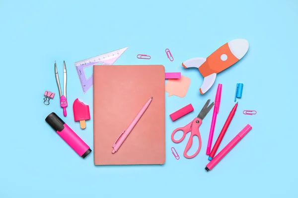 Paper rocket with school stationery on blue background