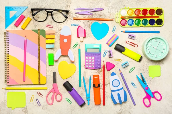 Paper rocket with school stationery and eyeglasses on grunge background