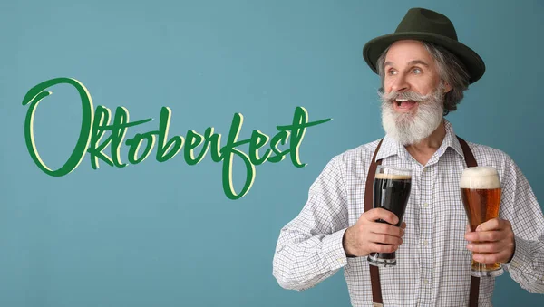 Handsome man in traditional German clothes and with beer on blue background. Oktoberfest celebration