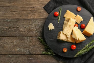Ahşap arka planda lezzetli parmesan peyniri ve domates vişneli pano.