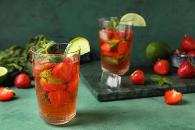 Yeşil arka planda bir bardak çilekli limonata, yakın plan.