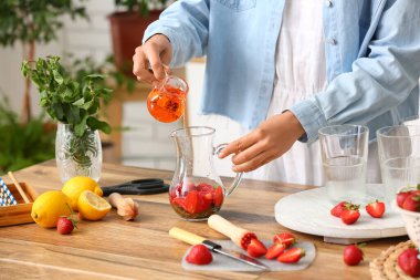 Mutfakta limonata içmek için akçaağaç şurubu dolduran kadın.