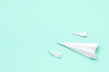 Renkli arka planda beyaz kağıt uçaklar