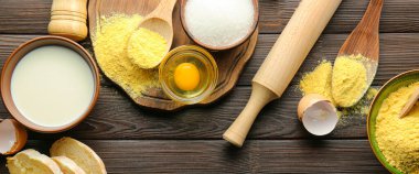 Taze ürünlü mısır unu ve ahşap arka planda mutfak aletleri.