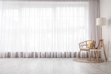 Hasır koltuklu, masa ve standart lambalı aydınlatma odasının içi