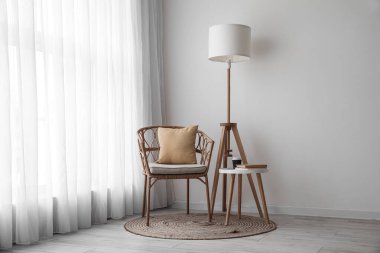 Hasır koltuklu, masa ve standart lambalı aydınlatma odasının içi