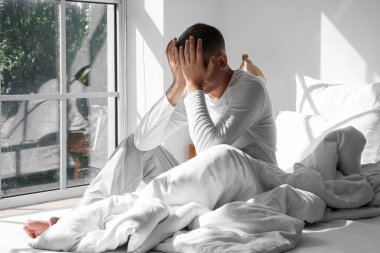 Genç adam sabah evde uyanıyor.