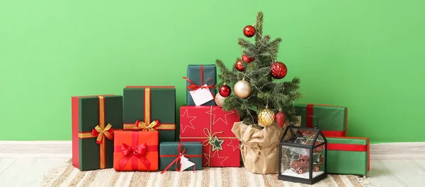 Купка Різдвяних Подарункових Коробок Ялинкою Біля Зеленої Стіни Кімнаті — стокове фото