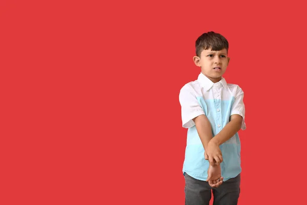 Kleiner Junge Kratzt Sich Auf Farbigem Hintergrund — Stockfoto