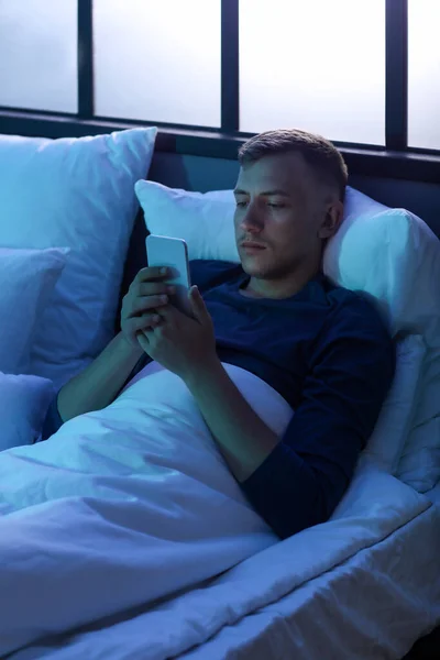 Young Man Using Mobile Phone Bedroom Night — Stock fotografie
