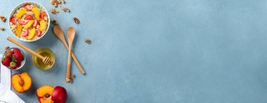 Composition with tasty oatmeal and fruits on light blue background with space for text