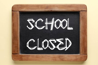 Chalkboard with written text SCHOOL CLOSED on light background