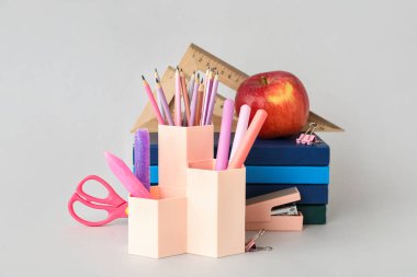 Okul kırtasiyeli fincanlar ve arka planda elma