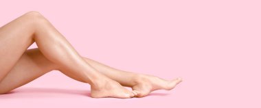 Legs of beautiful young woman on pink background