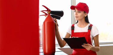 Fire safety specialist inspecting extinguisher in premises